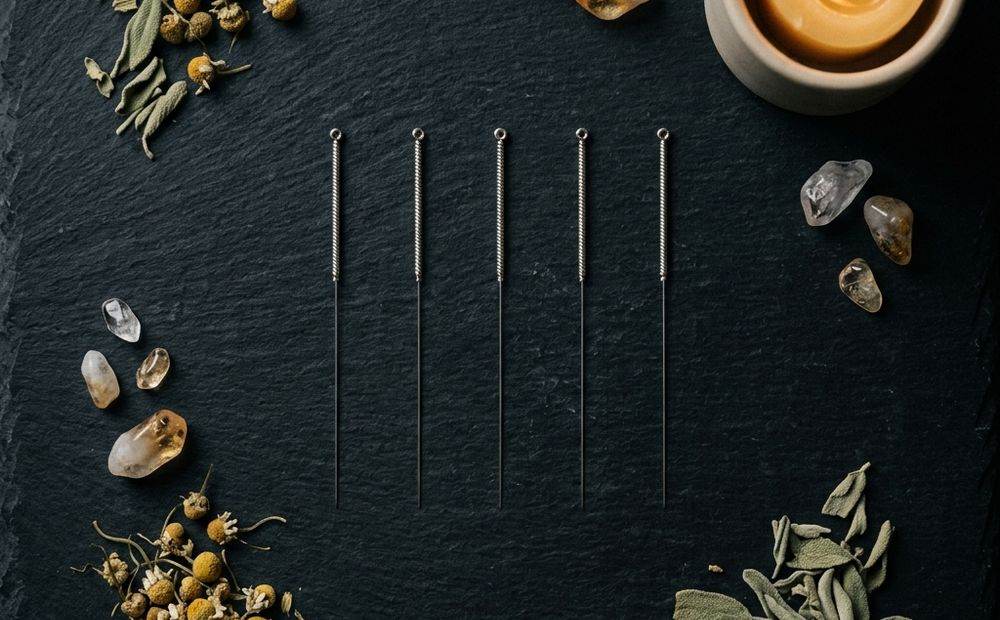 Agujas de acupuntura estériles, nuevas y sin abrir, sobre una superficie de pizarra
